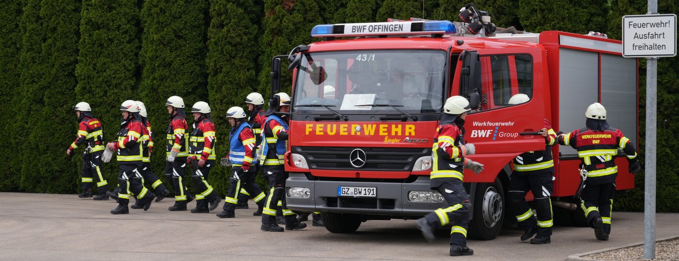 Mitglieder der BWF Group Werkfeuerwehr am Feuerwehrauto