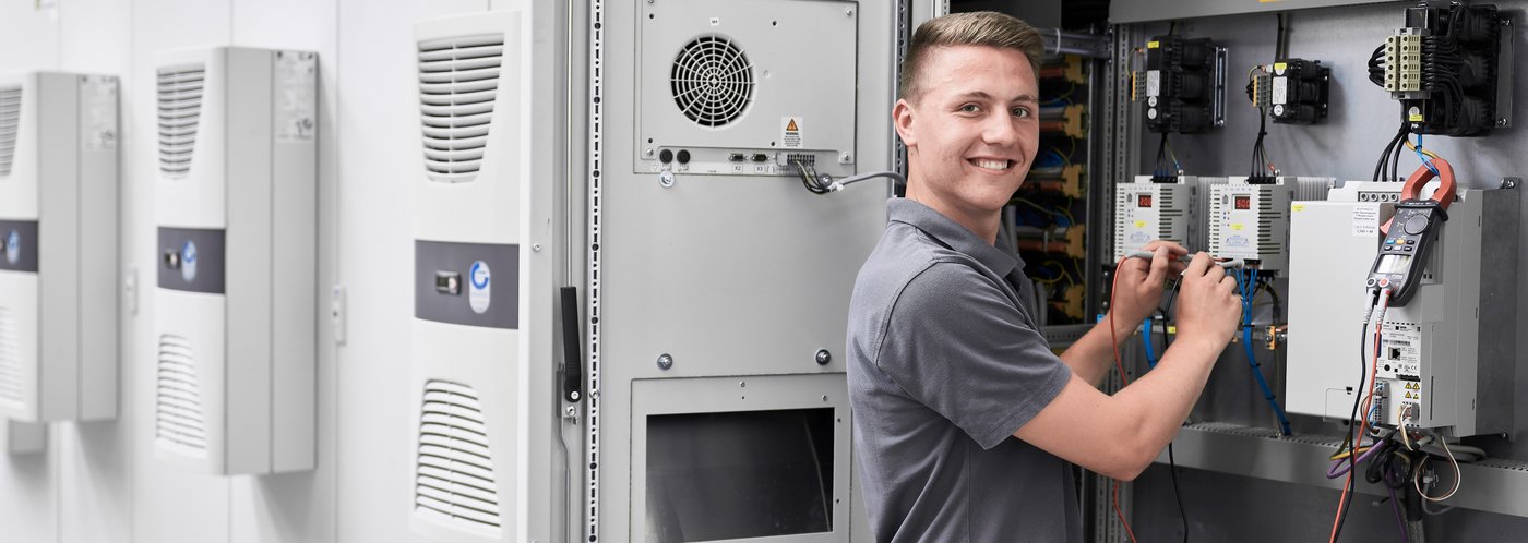 Ausbildung Elektroniker junger Mann vor Schaltschrank
