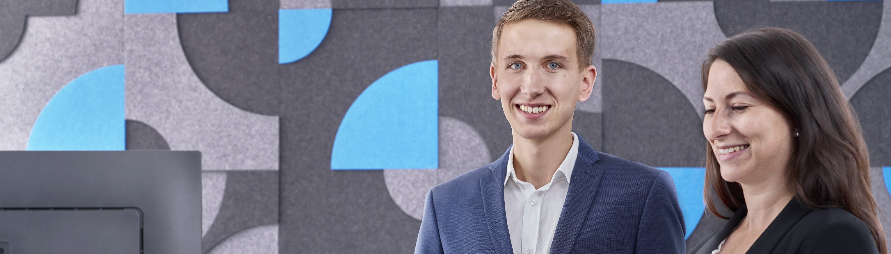 Zwei Mitarbeiter der BWF Group vor Filzwandbild